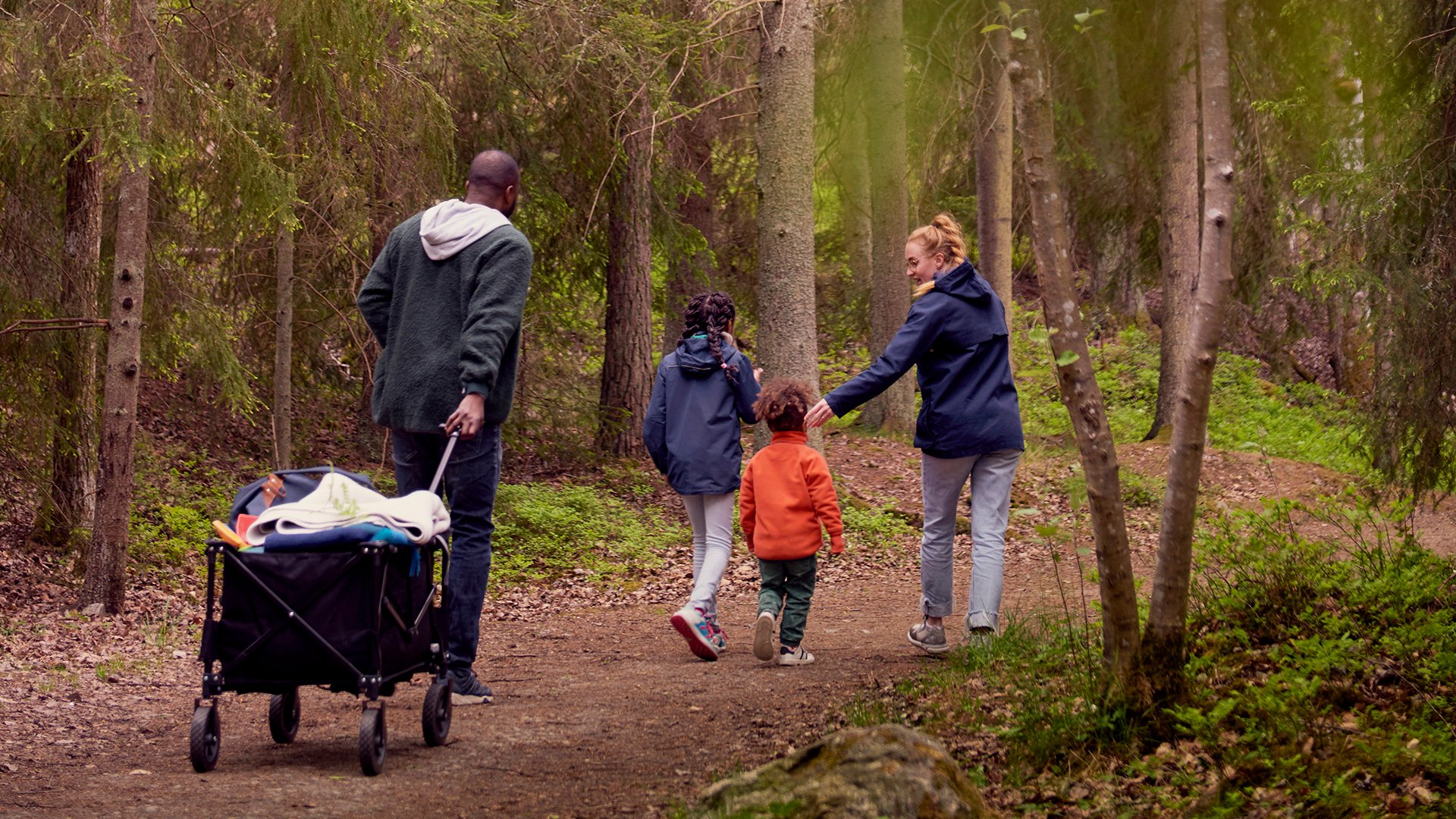 Fotograf: Maskot Bildbyrå
Bildbyrå: Johnér Familj med två barn promenerar i skogen och drar en campingvagn efter sig. Sverige.